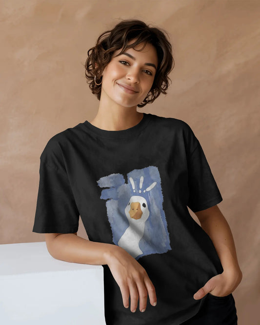 Woman wearing black printed oversized unisex t-shirt with goose graphic design, casual streetwear style