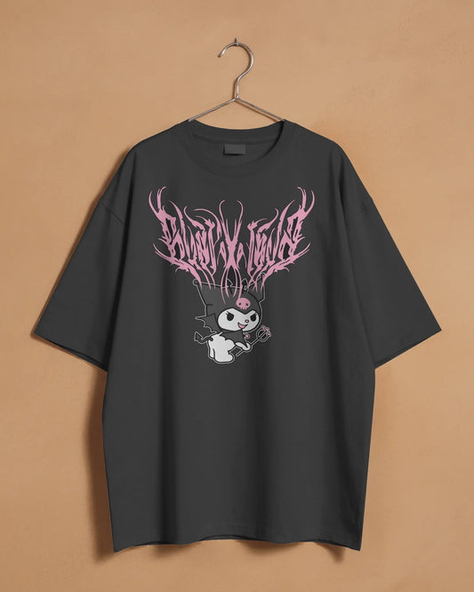 Dark Angel Kuromi Oversized T-Shirt in black, featuring a pink graphic design of Kuromi with dark, flowing text above, displayed on a hanger against a neutral beige background.