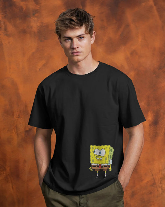 Front view of a male model wearing a black t-shirt and olive pants against a textured orange background. A small graphic of a happy SpongeBob SquarePants peeking out from a mock pocket is printed on the lower front of the shirt.